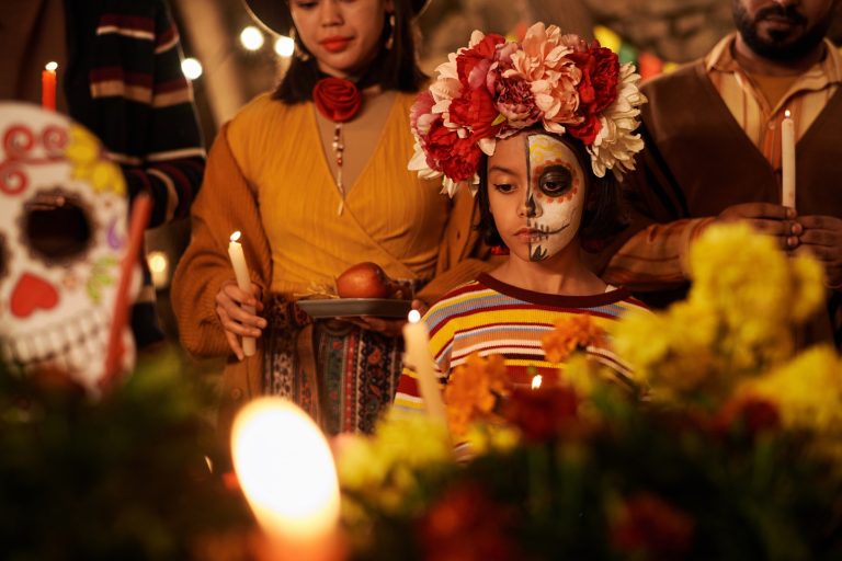 Fille avec le visage peint du Dia de los Muertos et une couronne de fleurs lors d'une célébration.